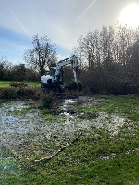 Digger working on clearing the pond
