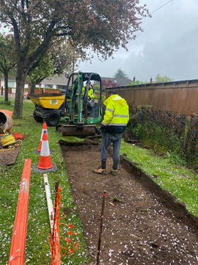 Workmen using a digger to excavate the new path
